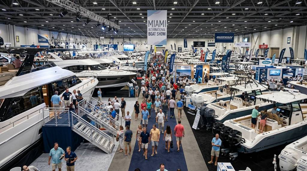 Visitors exploring luxury yachts and fishing boats at the Miami International Boat Show indoor exhibit hall